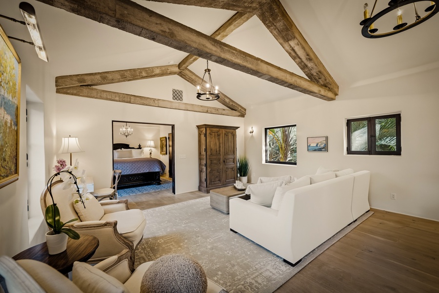 Relax in this stunning living area with exposed wooden beams overhead and plush white seating that invites you to unwind.