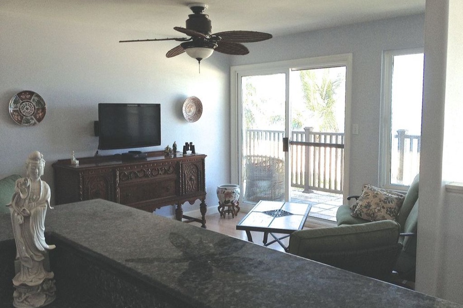 Living area with TV, fandelier, and is located adjacent to the kitchen.