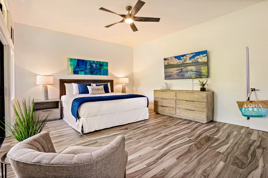 With modern furnishings and natural light, the spacious primary bedroom at Kapalua Ridge 1421 opens to a private lanai.