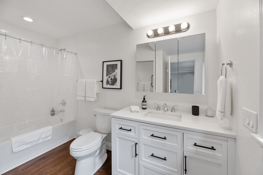Ensuite bathroom with a white finish vanity space and a shower tub.