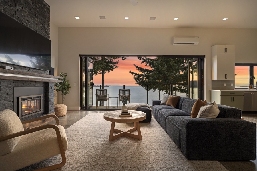 Evening glow fills the living room — gather inside or step out to take in the final colors of sunset over the bay.