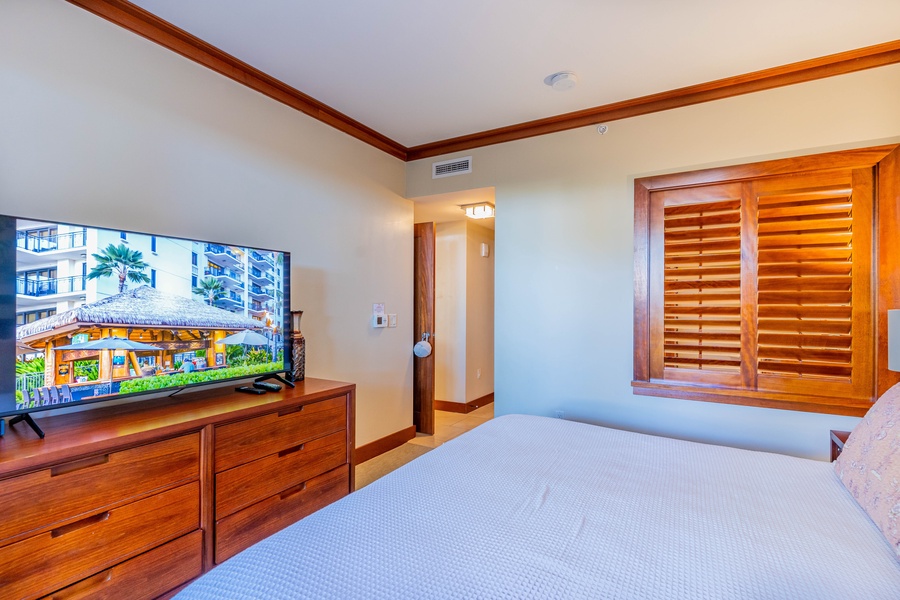 The primary guest bedroom has luxury linens and a spacious dresser.