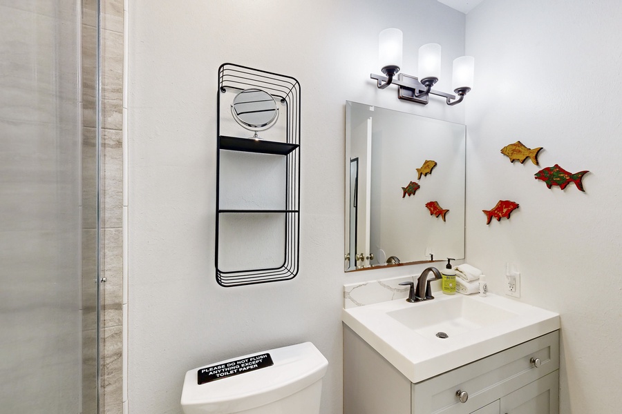 Vanity area with bright lighting and storage shelves.