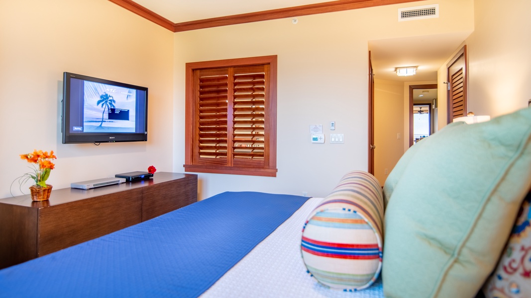 The primary guest bedroom also features a ceiling fan and TV.