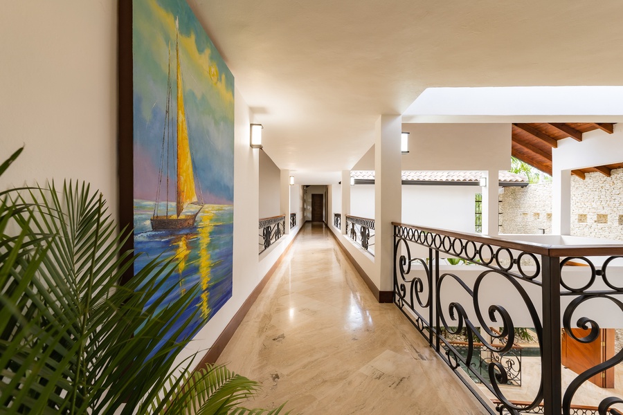 Beautifully designed hallway with decorative railings and artwork, leading to the various rooms of the house.