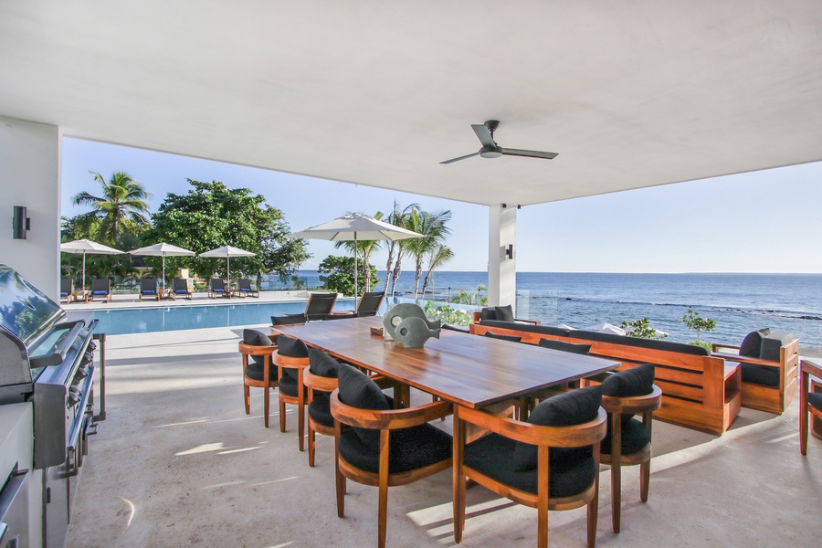 Enjoy outdoor dining with ocean views, complete with a large table and barbecue area.