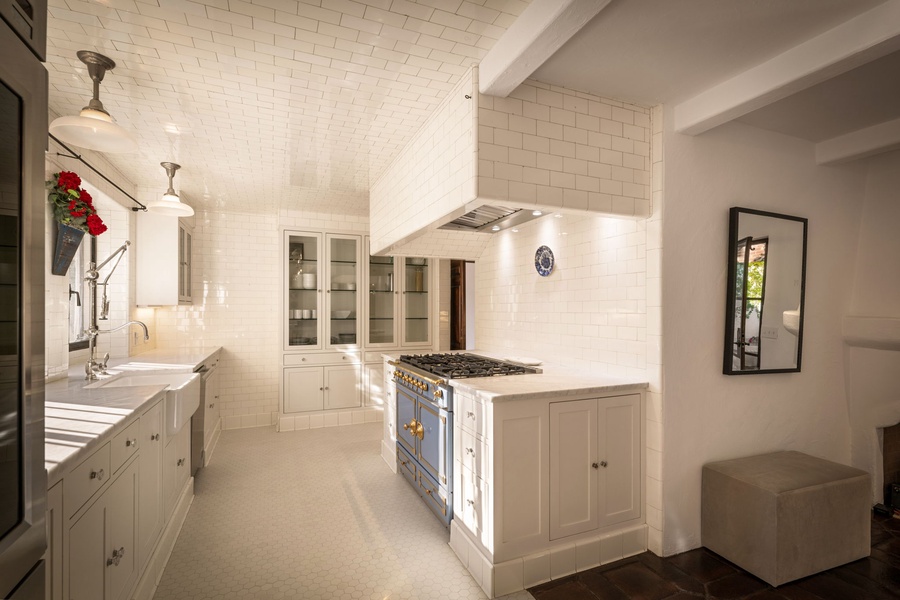 With marble counters, a pro-grade range, and gleaming subway tile, this chef’s kitchen blends utility and style for seamless entertaining.