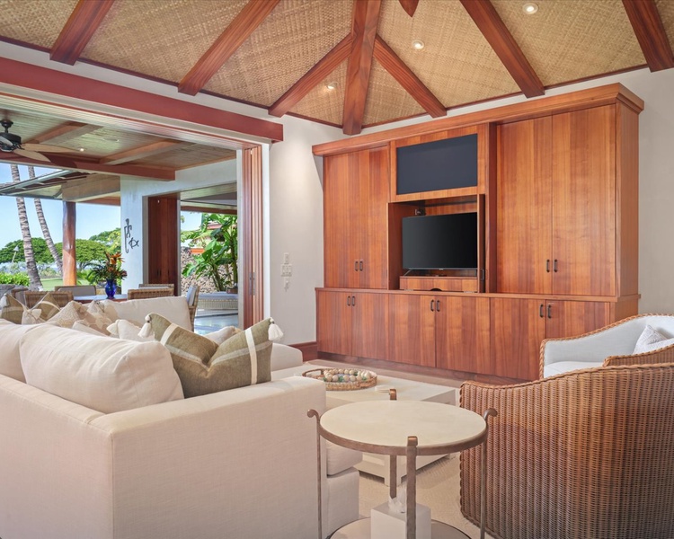 The living room offers a retreat for relaxation with floor to ceiling pocket doors to the lanai