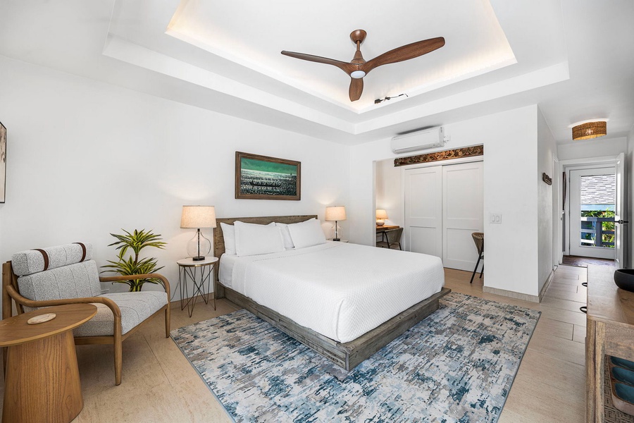 The primary bedroom keeps its ceiling fan turning and the light soft and low.
