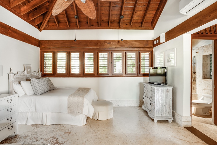 The third guest suite features a king sized bed, footboard bench, TV and split AC.