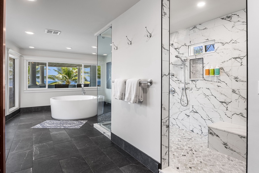 Primary bathroom features a marble walk-in shower and jetted soaking tub with ocean views.