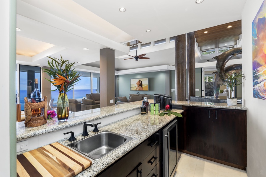 Bar area features granite countertops and premium appliances, opening seamlessly to the living area where ocean views await.