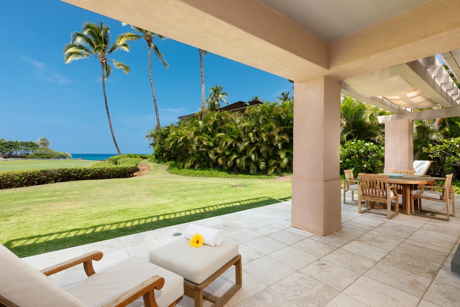 Your private terrace opens to tropical paradise, where teak furniture awaits under swaying palms with endless ocean views.