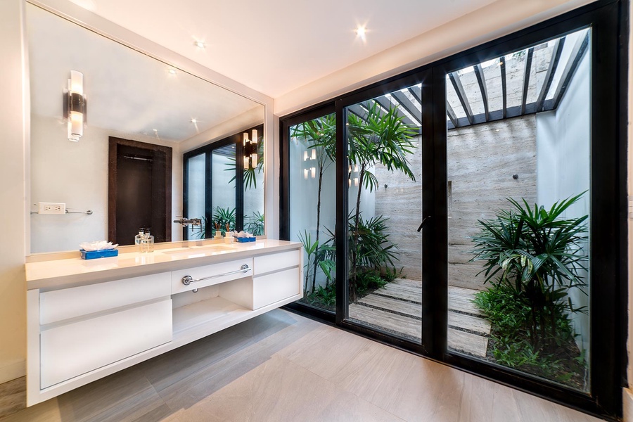 Refresh in this contemporary bathroom with dual vanities and an open-air shower area.