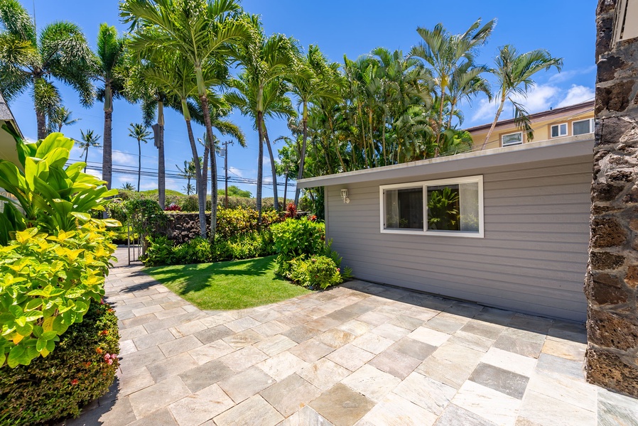 A tropical paradise awaits with lush palms framing manicured lawns and a private patio, perfect for morning coffee or evening relaxation under swaying fronds.