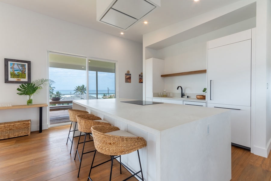 Fully-stocked kitchen with island bar seating for three.