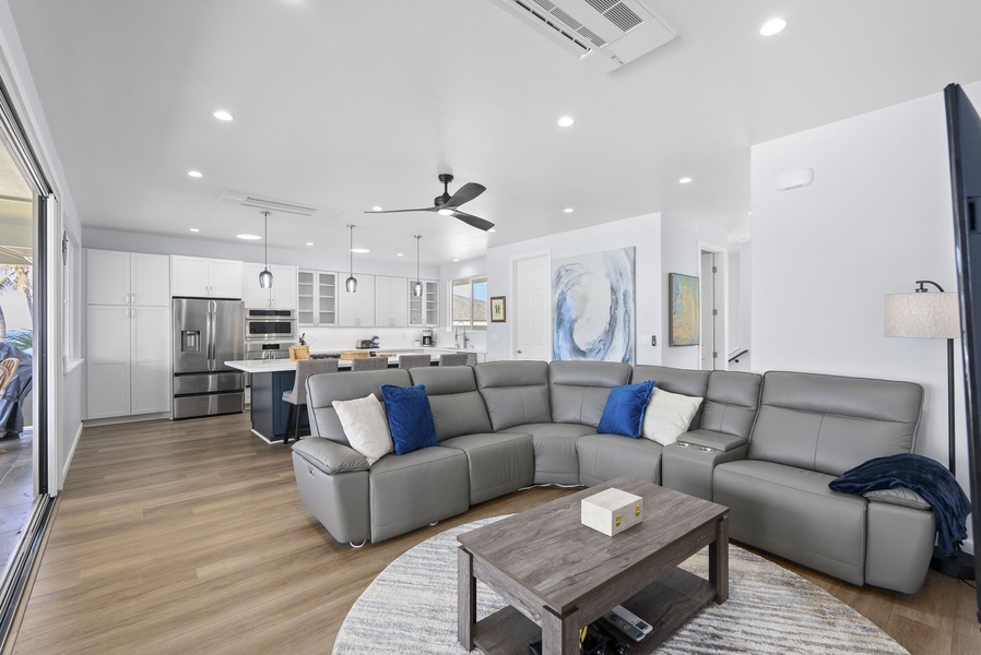 Spacious oceanview living room with sectional seating, coastal artwork, and central A/C.