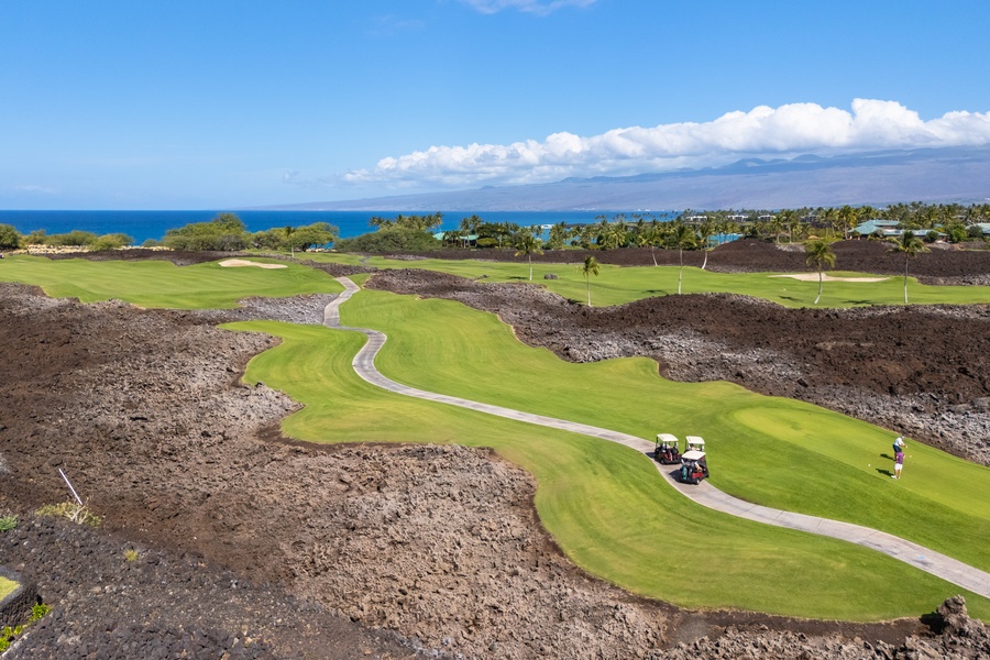 Stunning oceanfront golf course with dramatic lava rock formations and pristine fairways stretching toward tropical coastline.