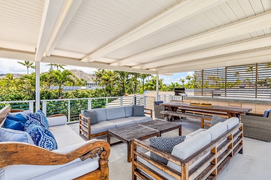 Rooftop deck with built-in BBQ, lounge, and dining spaces with peekaboo ocean views.