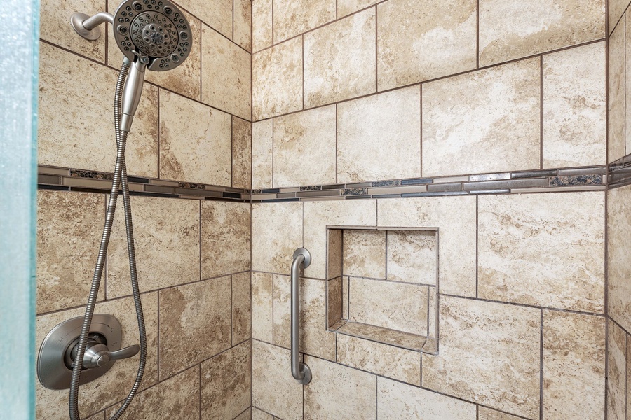 Step into a warm, inviting shower with elegant tilework and a glass enclosure – perfect for unwinding after a day of island adventures.