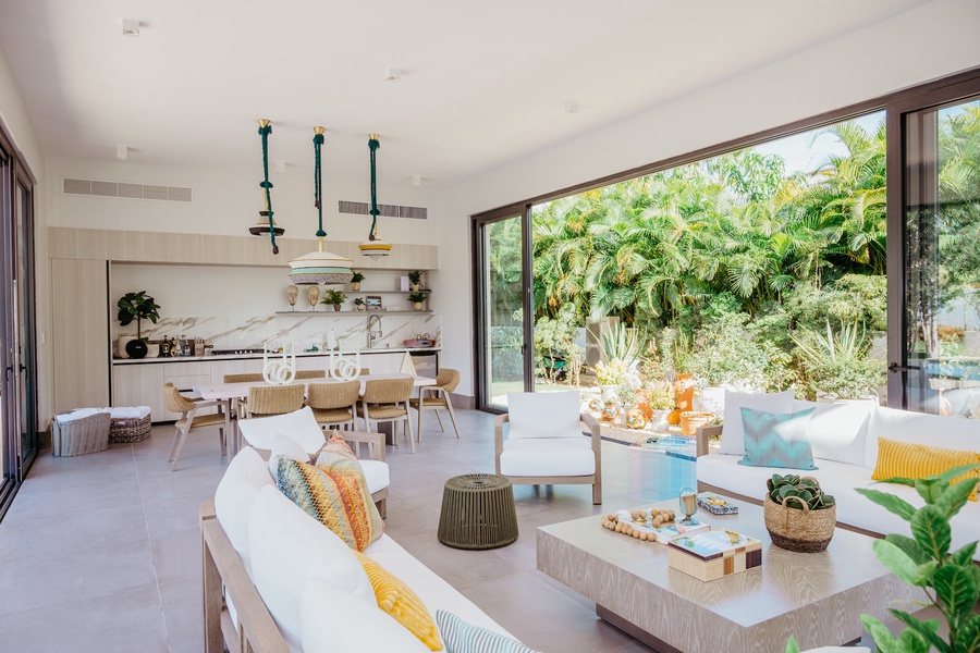 Open layout featuring a dining and spacious living area, surrounded by well-manicured gardens.