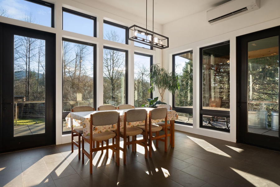 Sunlit dining table where floor-to-ceiling windows frame peaceful garden views, creating the perfect setting for your morning coffee.
