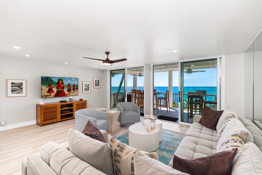 Living room with panoramic ocean views and lanai access for seamless indoor-outdoor living.