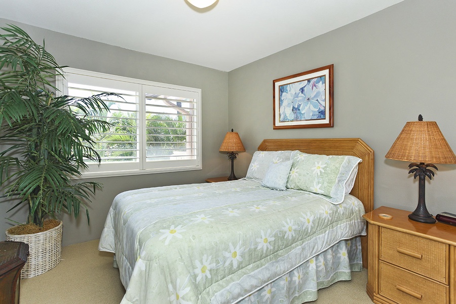 The second guest bedroom is tastefully decorated with soft patterns and linens.