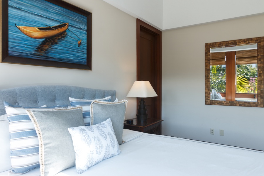 Unwind in your serene bedroom with coastal artwork and soft blue linens creating the perfect tropical escape atmosphere.