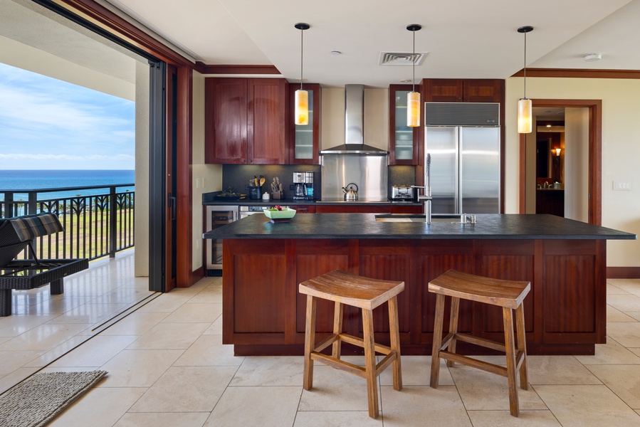 Cook with ocean views from your gourmet kitchen, complete with granite island, premium appliances, and sliding doors to the sea breeze.