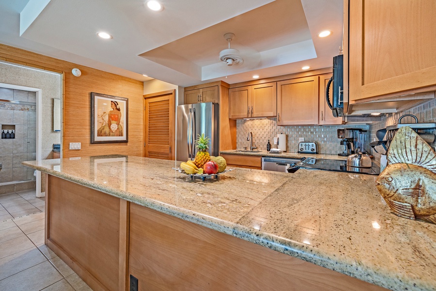 The kitchen island with its expansive granite countertop is perfect for meal prep or casual dining, with modern appliances and plenty of storage space.