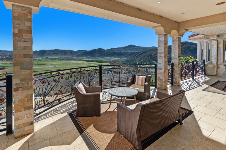 Out here the covered loggia trades walls for a wide-open valley.