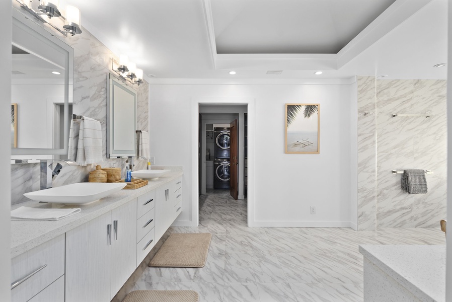 Dual vanities, marble floors, and spa-style touches make this ensuite bath a rejuvenating retreat.