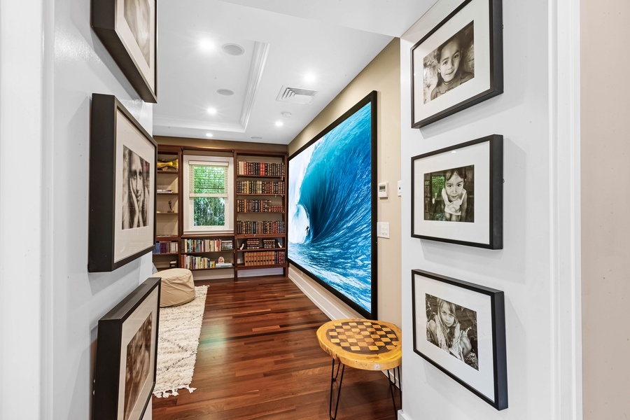 Media hallway with ocean wave projection and art-lined walls.