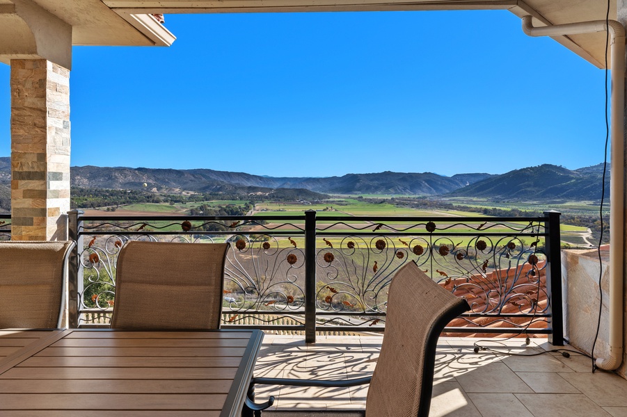 Out on the covered loggia, the lounge chairs face open country.