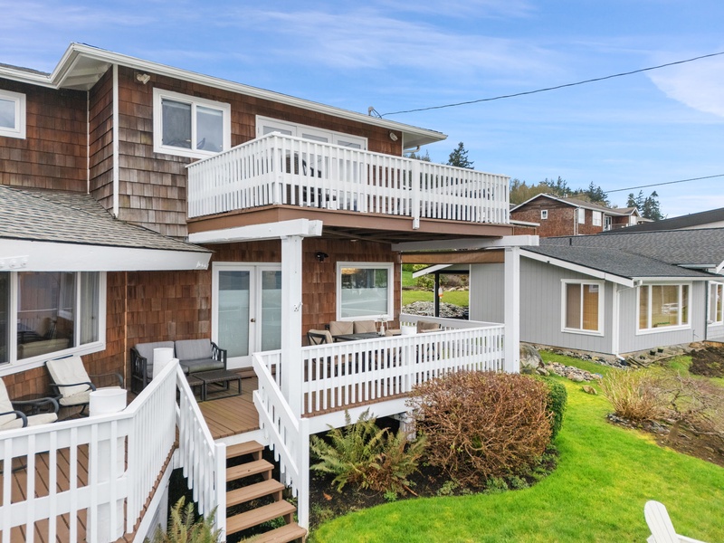 Charming coastal property features multi-level decks perfect for morning coffee and evening relaxation in a peaceful neighborhood setting.