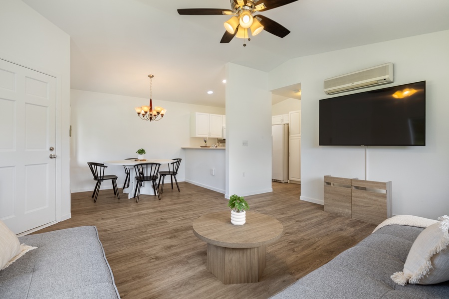 Relax in your bright, modern living space with a comfy sofa, dining table, and large TV for your entertainment.