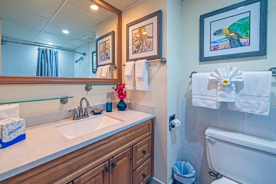 This bathroom offers a spacious vanity with ample storage and sleek fixtures, perfect for a comfortable stay.