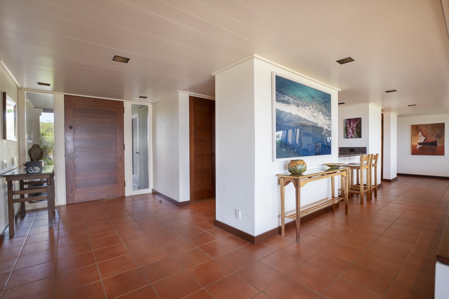 Bright entryway with artful details and natural tile flooring welcomes you into your Big Island retreat.