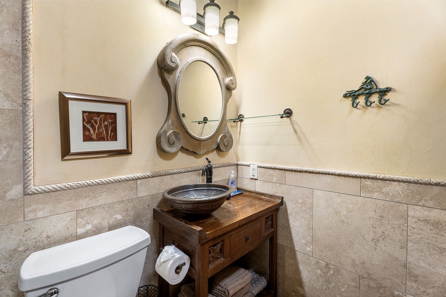 Ornate mirror and artisan sink elevate this guest bath with thoughtful island detailing.