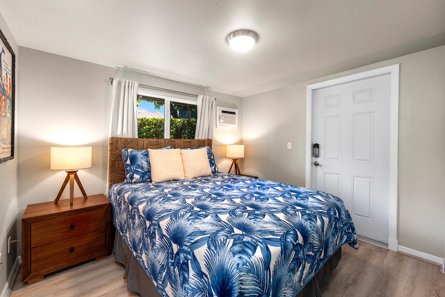 Guest bedroom with queen bed, cozy lighting, and tropical charm.