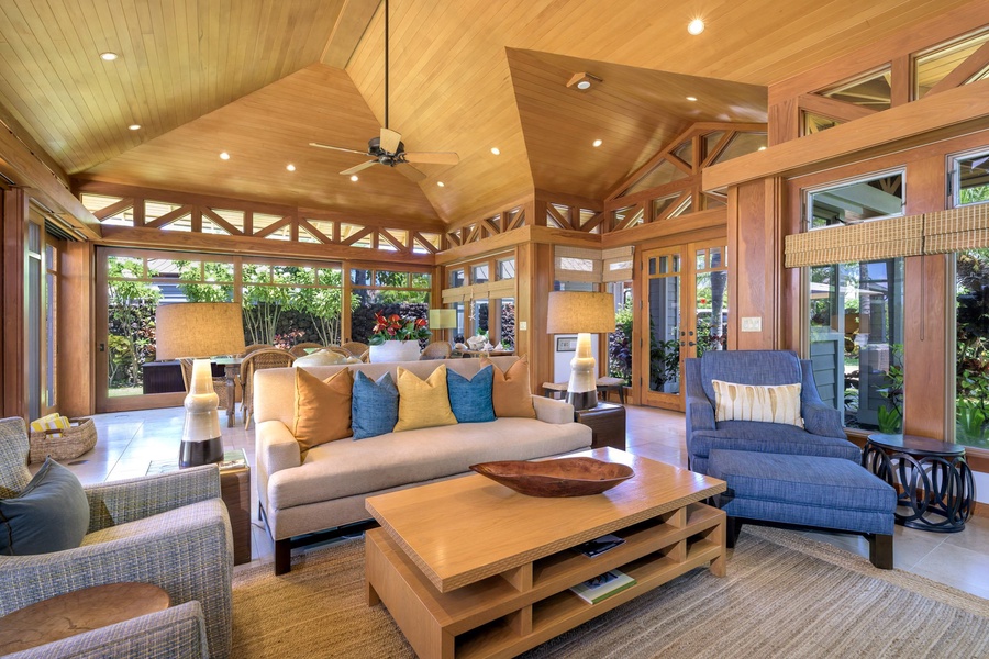 The heart of the home, the open living area, boasts comfortable furnishings set under natural wood vaulted ceilings, amplifying the sense of space and warmth.