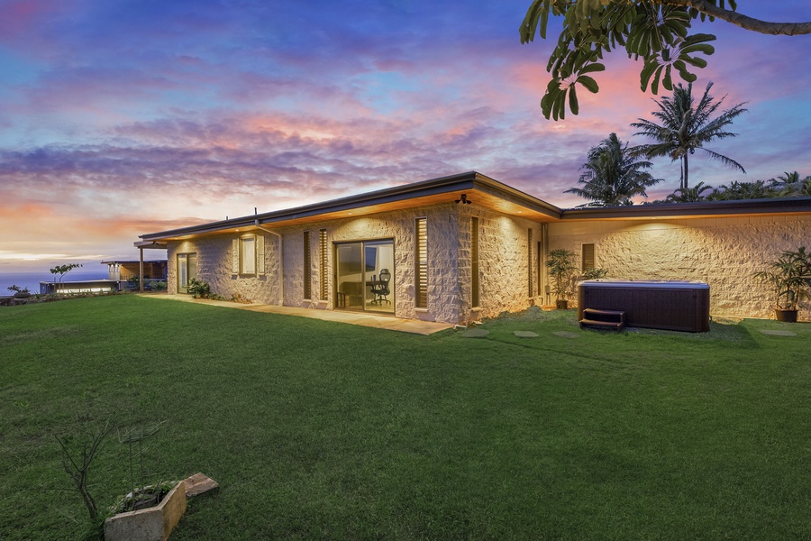 Twilight hues settle over Hale Mahina’s front yard—an ideal spot for sunset reflections surrounded by lava rock privacy.