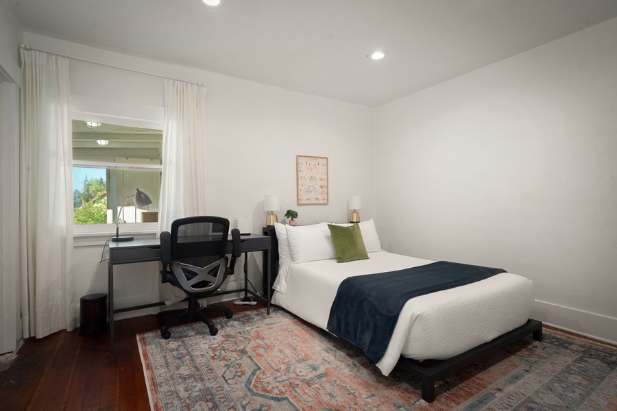 Recharge in this quiet bedroom with a workspace, soft linens, and warm natural light.