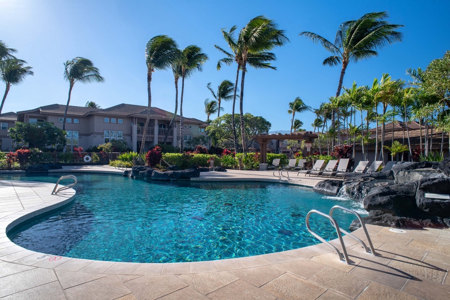 This beautifully landscaped pool features a cascading rock waterfall and ambient palm shade for a soothing swim experience.