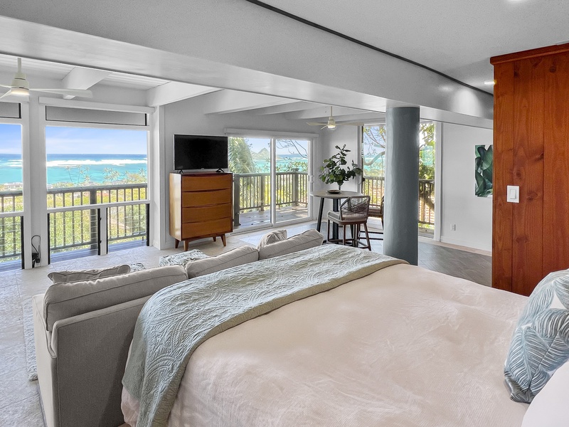 Guest bedroom has a flat screen TV, sweeping ocean views, and a private seating area