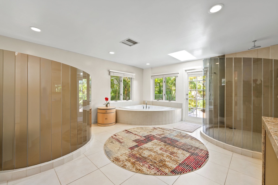 Elegant primary bathroom with a large soaking tub, perfect for unwinding and enjoying the serene garden views.