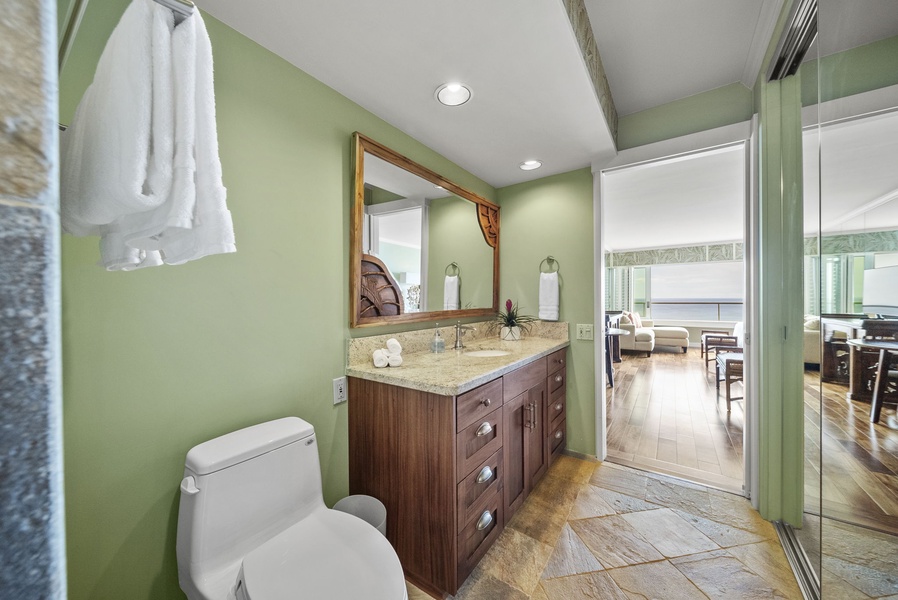 Modern bathroom with upscale details, natural wood cabinetry, and ample lighting for a comfortable and refreshing experience.