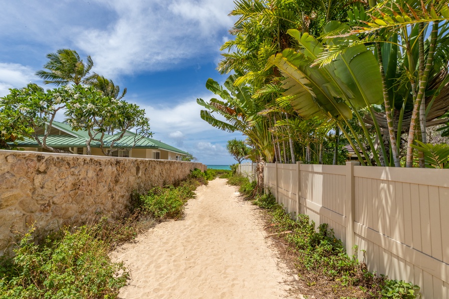 The sandy path leads to turquoise waters