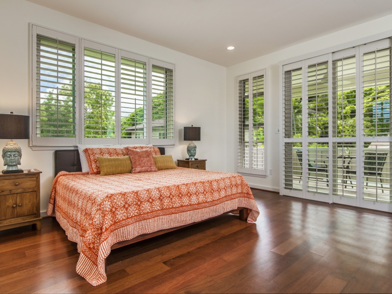 Doors lead to a covered second-floor lanai and offer privacy for the primary bedroom.